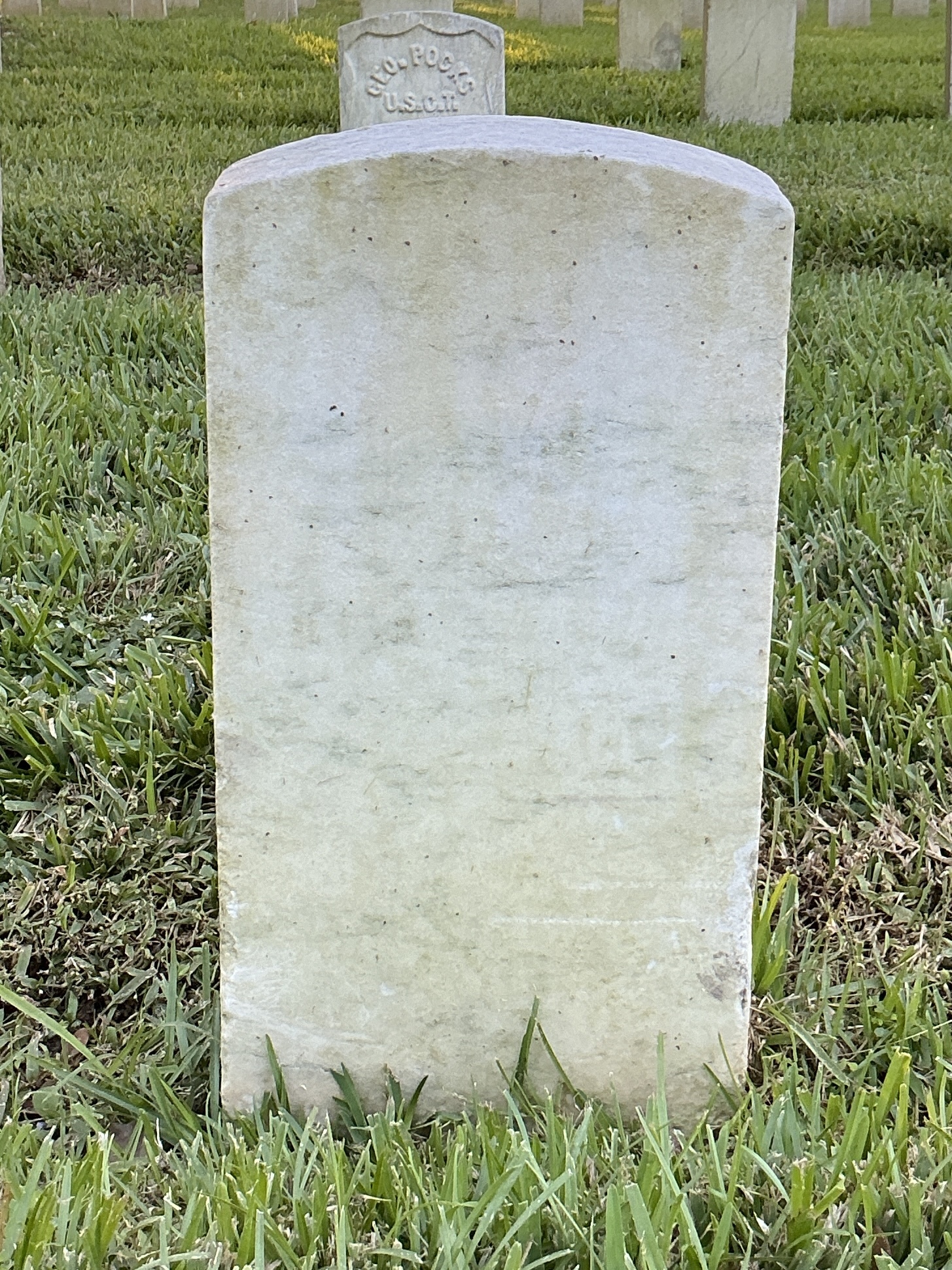 Back of historic upright marble headstone with recessed shield face.