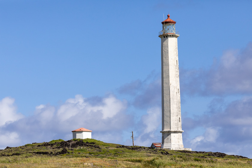 A tall, thin white structure on a landscape