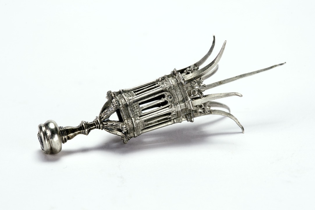 A small silver cigar pierce in the form of a lantern, with central pick protruding at top.