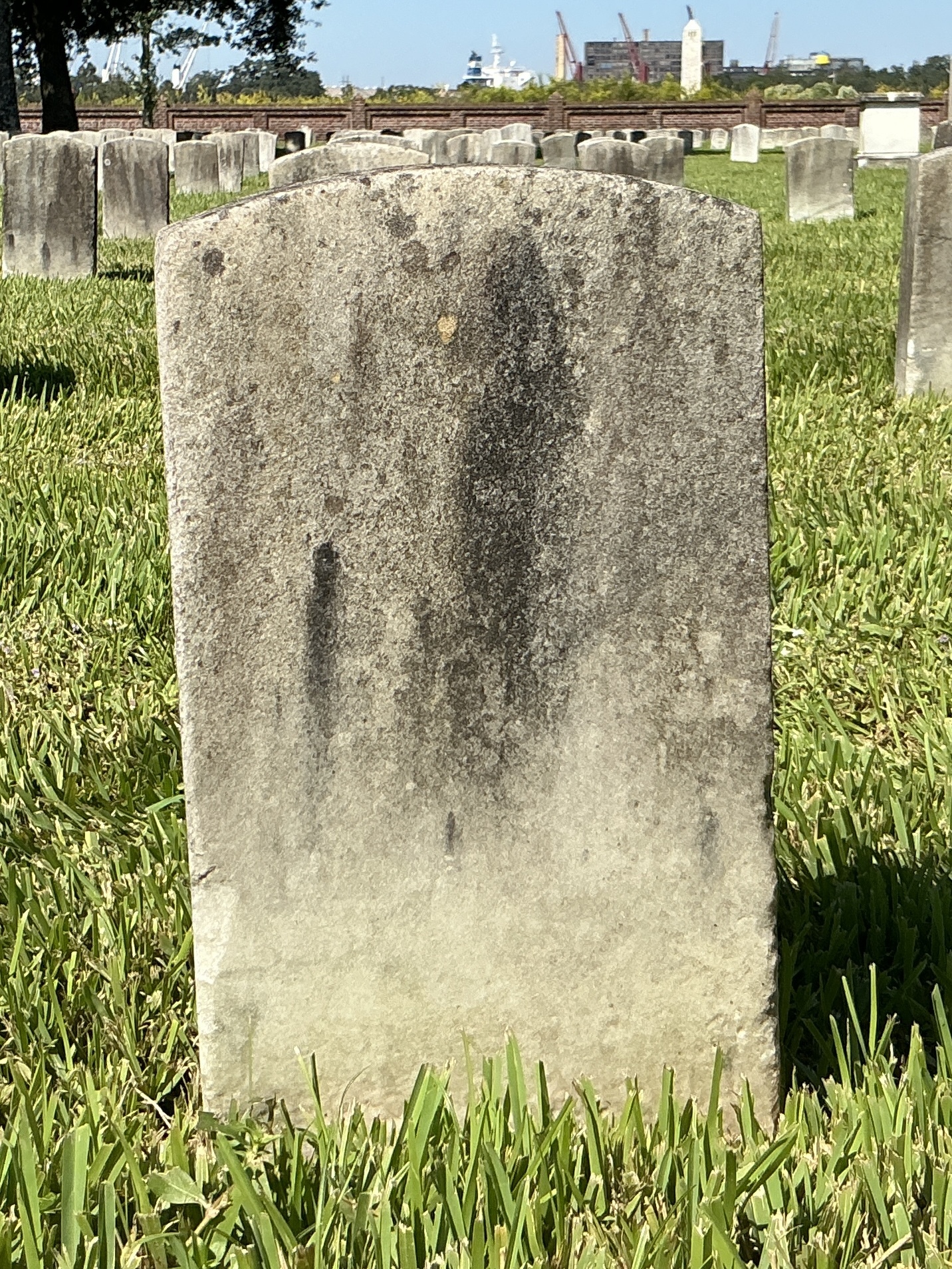 Back of historic upright marble headstone with recessed shield with recessed lettering face.