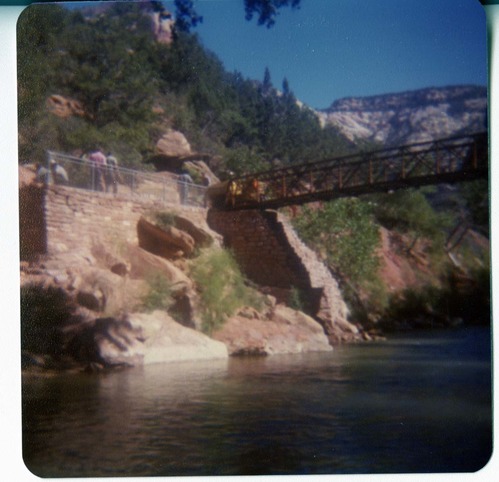 Men working on trail by the new Grotto footbridge. Overview of stone abutment for bridge and trail along Virgin River.