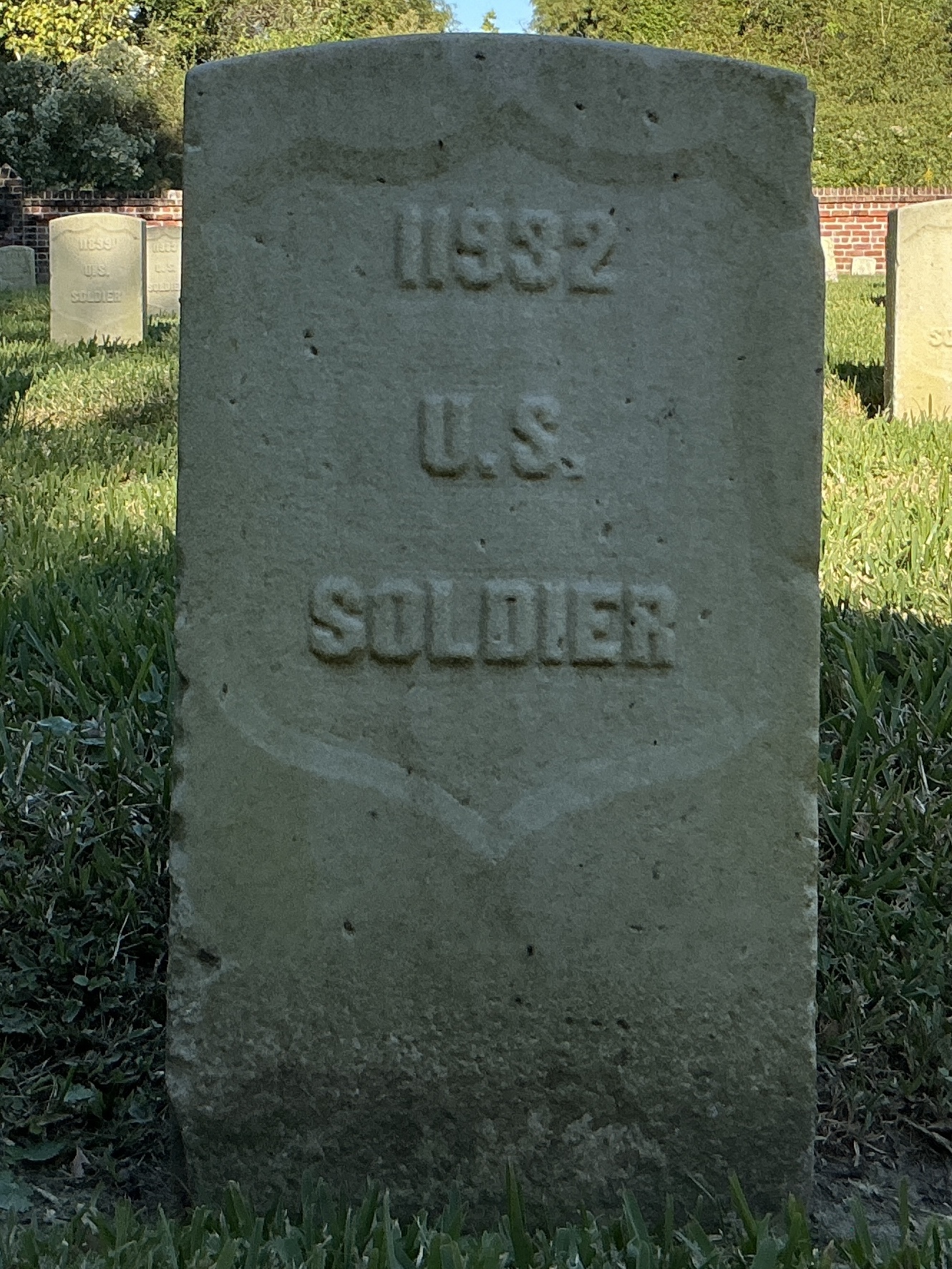 Front of historic upright marble headstone with recessed shield face.