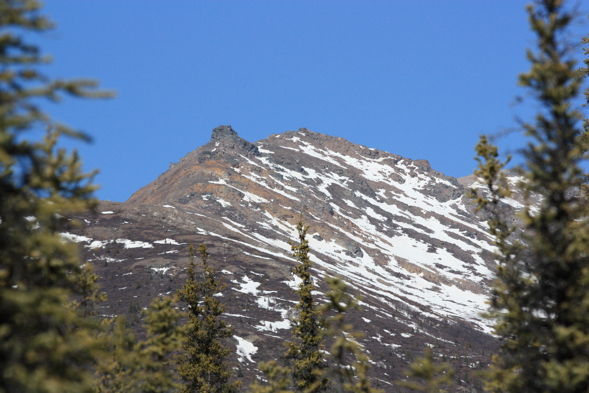 a mountain with snowfields on its flank