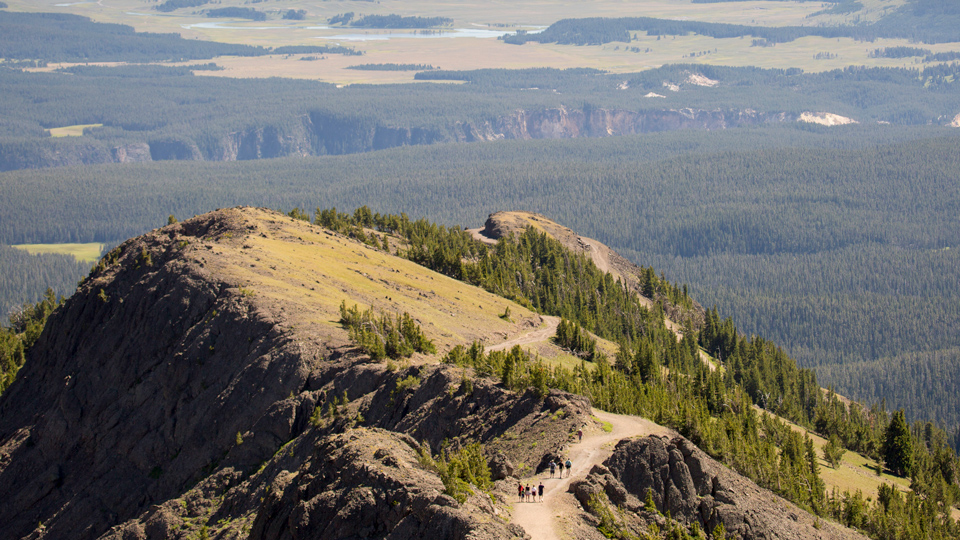 Looking down on hikers walking a mountain trail.