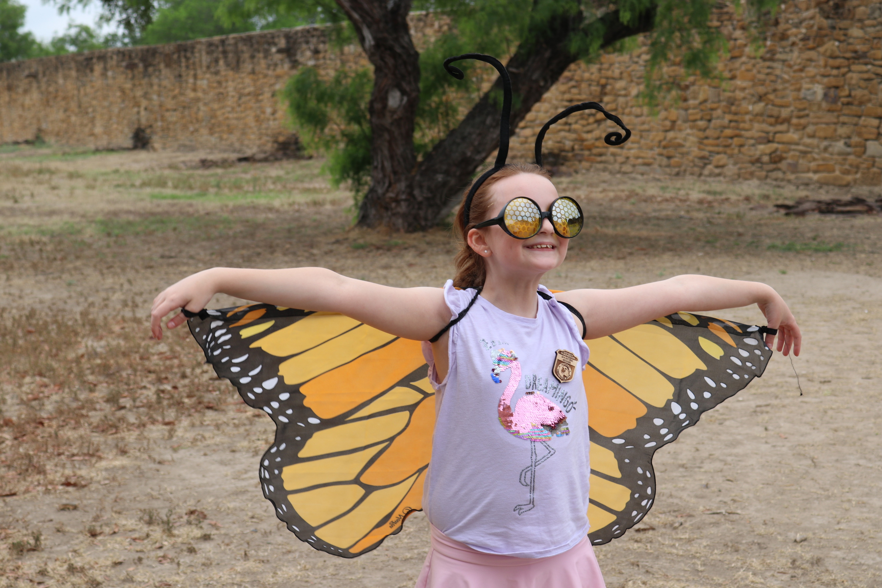 Girl dressed up as a monarch butterfly smiling. 