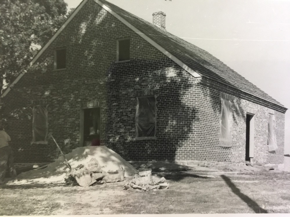 Brick building under construction with dirt pile on side