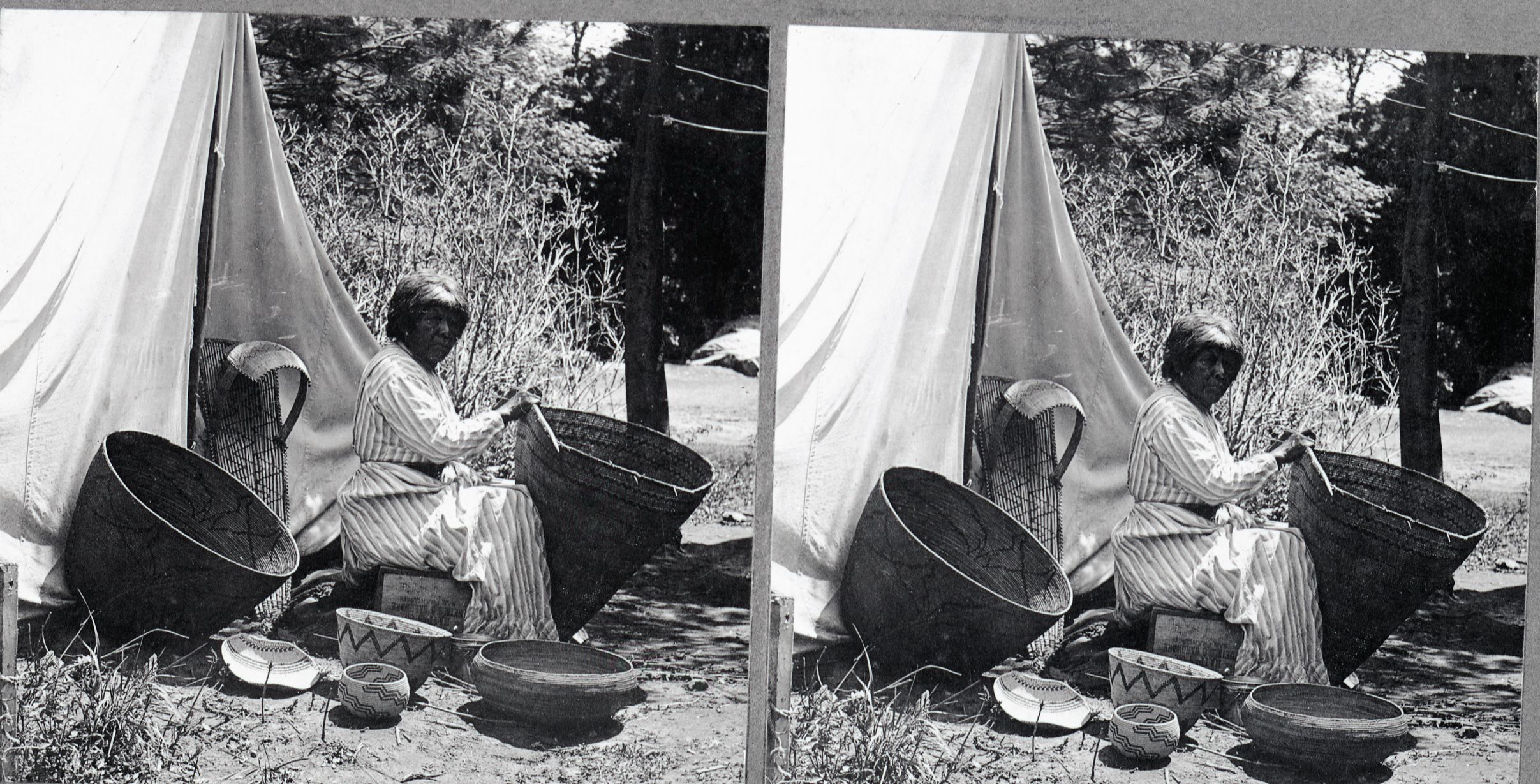 Copy Neg: 11/85 by M. Dixon; Stereo from L. Smaus collection; silver print on grey card. Native American Mary repairing a Western Mono Burden basket. The other baskets set about are from Boysen's collection. Same image (YM-8409)