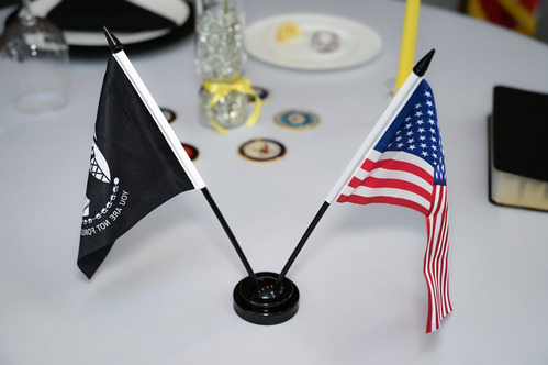Table with the American flag, POW flag, a Bible, a lemon and a plate designated for the POW's and those MIA.