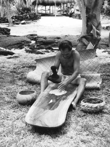 Man in traditional clothing pounds poi in the Royal Grounds