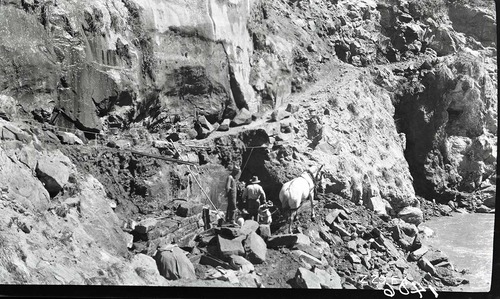 Narrows Trail construction- view of cement and rubble masonry wall at station 30-60. Five workers are drilling with a draft horse.