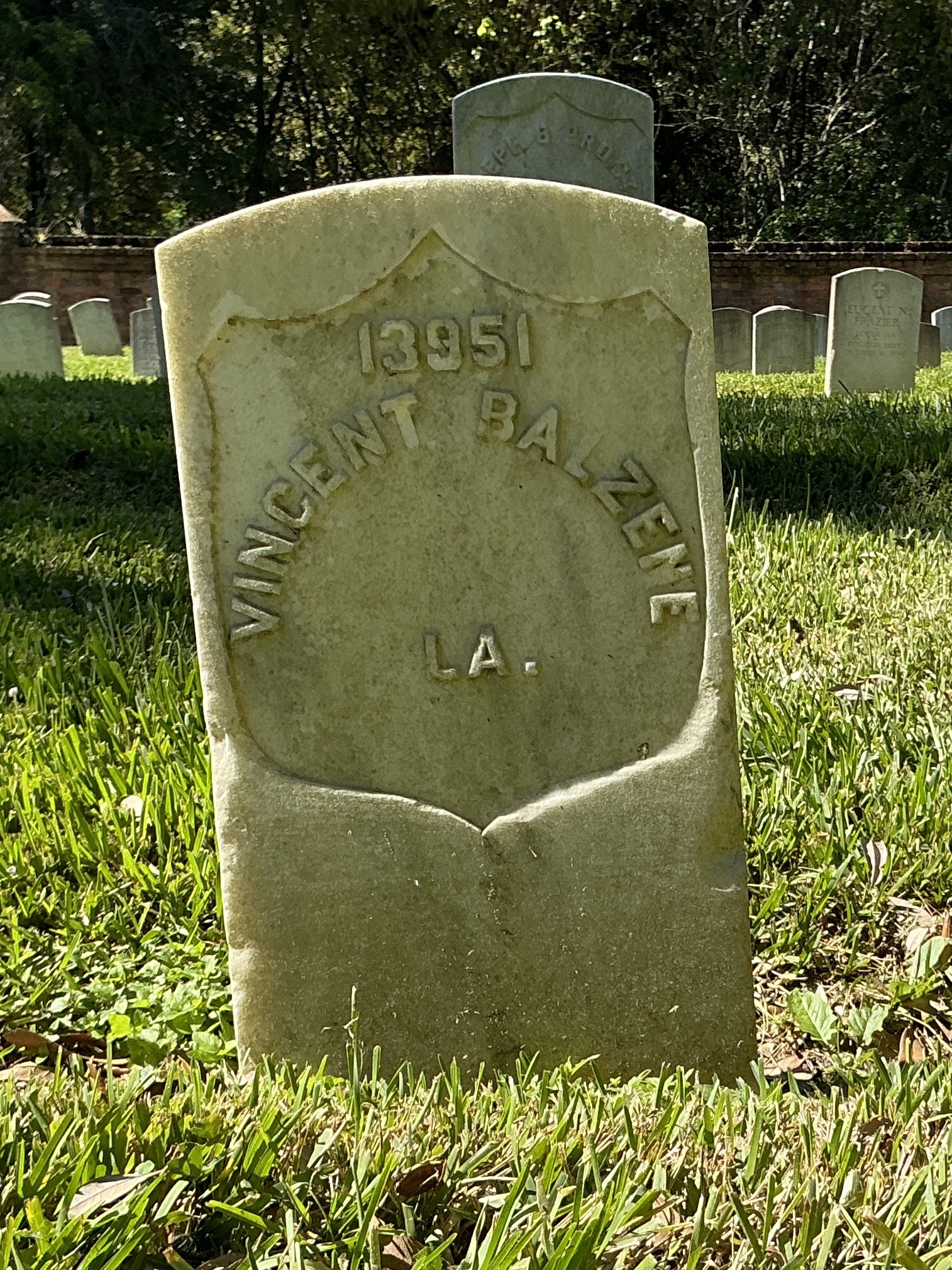 Front of historic upright marble headstone with recessed shield face.