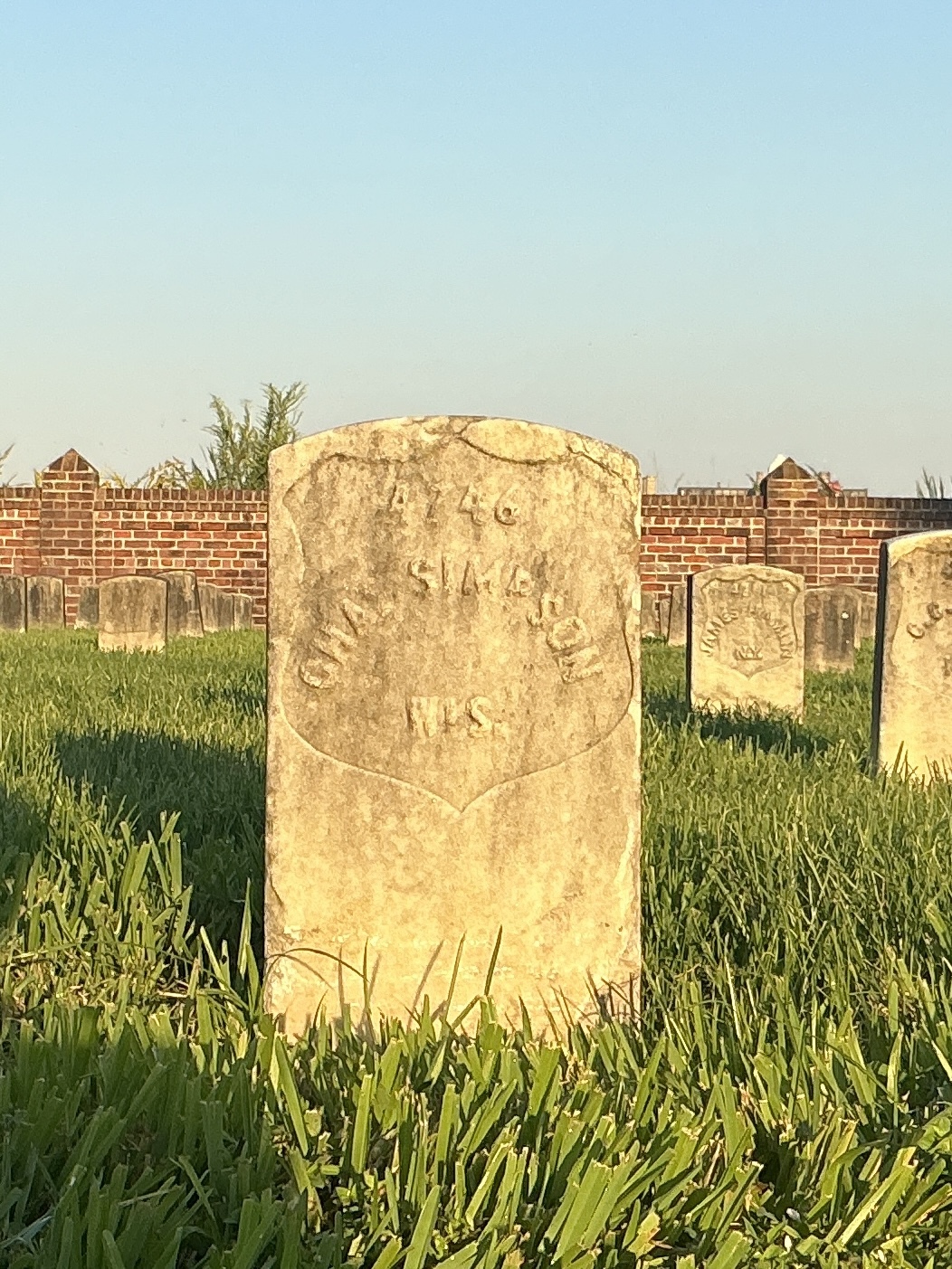 Front of historic upright marble headstone with recessed shield face.