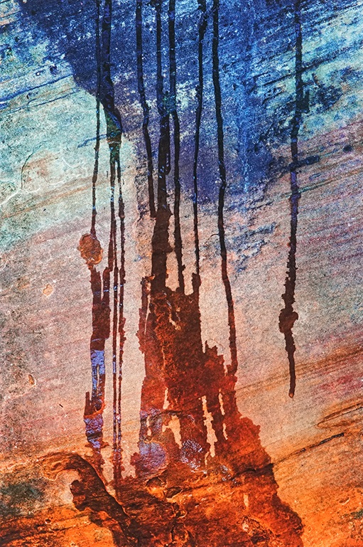 water streaks running down a rock face