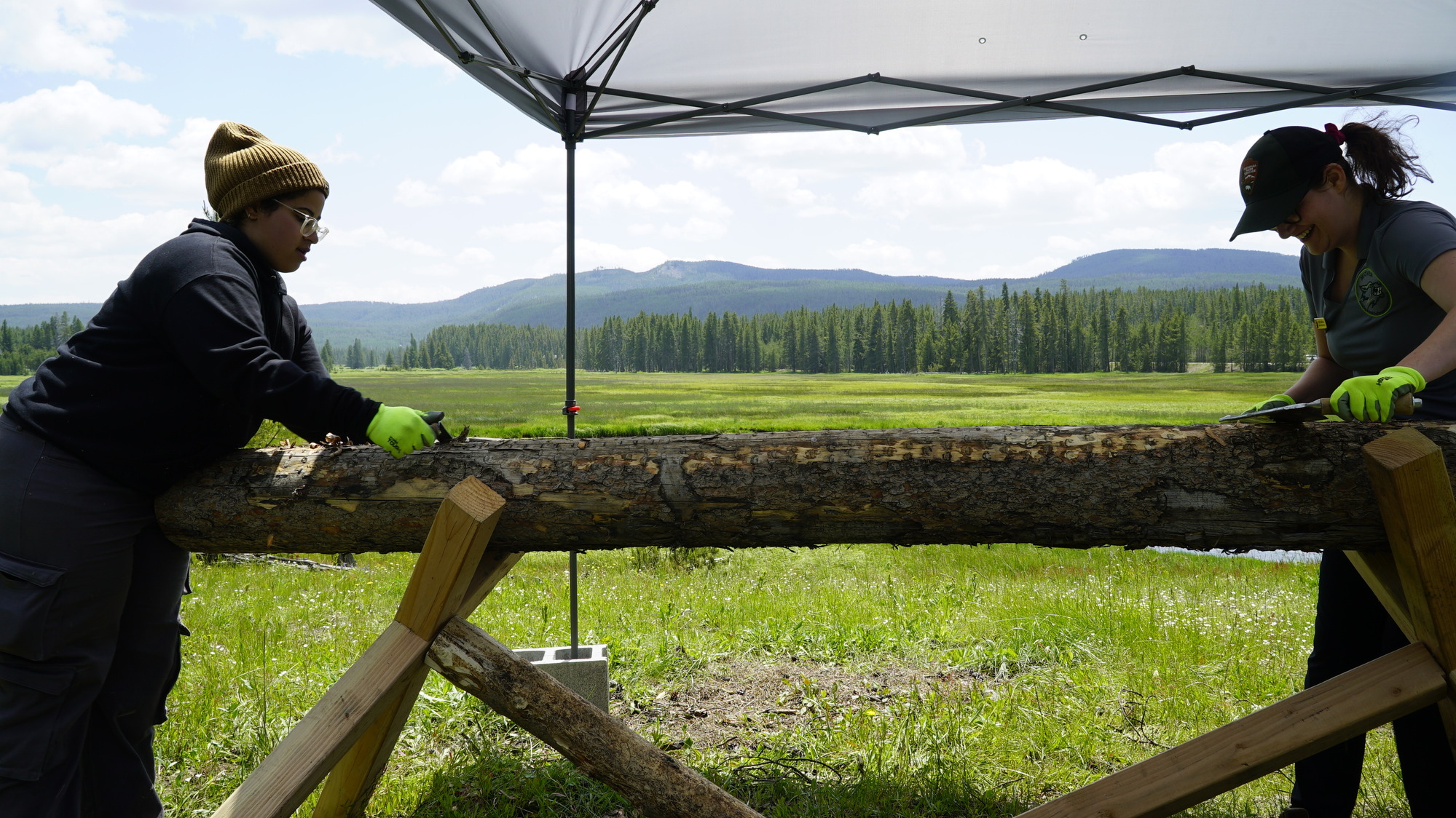Two women using draw knives.