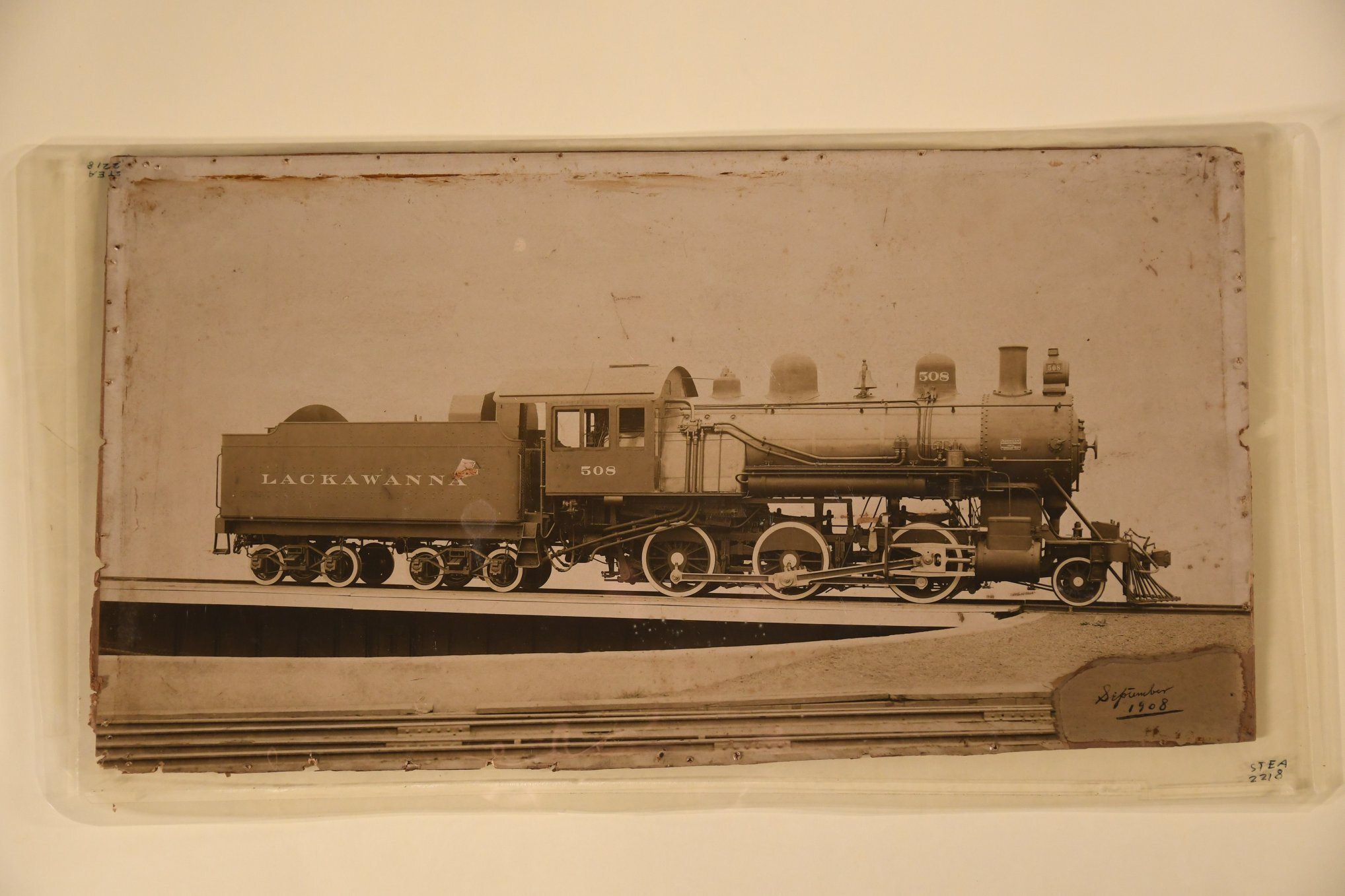 Print, photographic. 09/1908. DL&W RR Locomotive No. 508, A 2-6-0 "Mogul," on turntable. engineer's side. "American/Locomotive Company/405534/Schenectady Works/September 1908" on builder's plate. "Lackawanna" on tender. image peeled lower right, "September/1908" written in ink. Hole near "a" on tender. Had been framed, tack holes around edges.