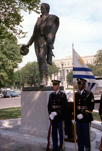 Statue of Jose Artigas with military from Uruguay one holds a flag