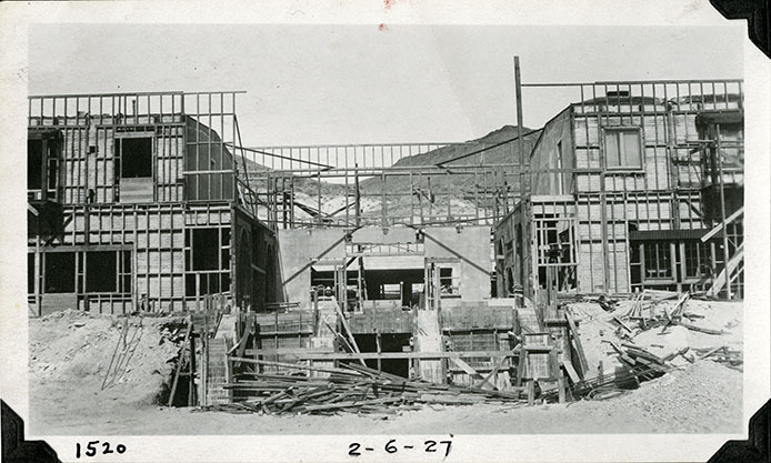 This is an historic black and white photograph from the Scotty's Castle Historic Photograph Collection, Death Valley National Park of Scotty's Castle Main House, looking north. Forms for basement under Great Hall and Front Porch poured. February 6, 1927. Photographed by Mat Roy Thompson.