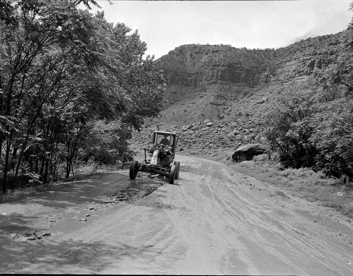 Grader clears flood debris off road near South Entrance.