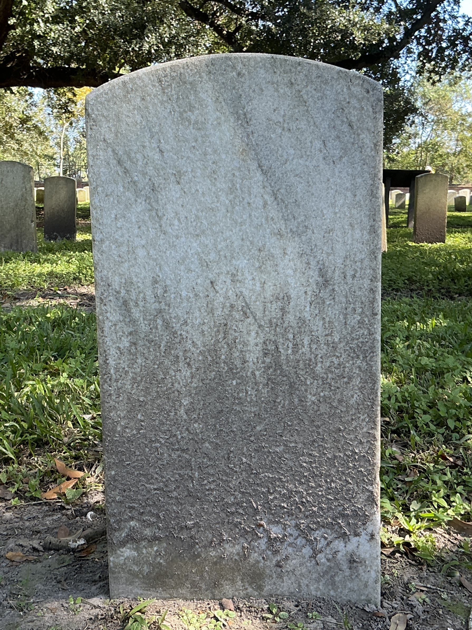 Back of upright marble headstone with flat face.