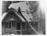 CCC Worker Painting Warner Valley Ranger Station Roof. Administrative Collections: Album 5 (Emergency Conservation Works) -Worker painting roof of Warner Valley Ranger Station