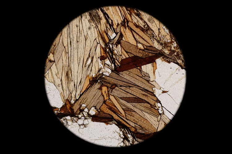 Circular microscopic image of rock structure.