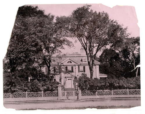 Georgian mansion from across the street framed by two tall trees