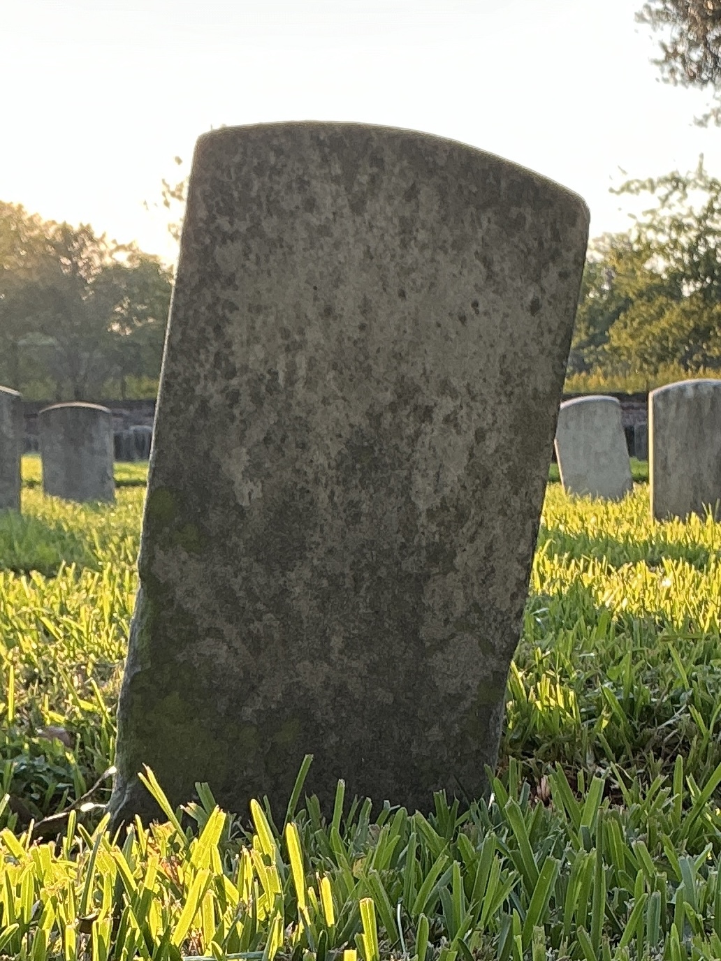 Back of historic upright marble headstone with recessed shield face.