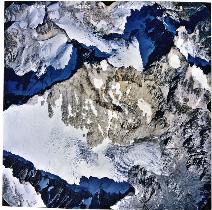 Color aerial photograph of glacier and snowfields on mountain peak.