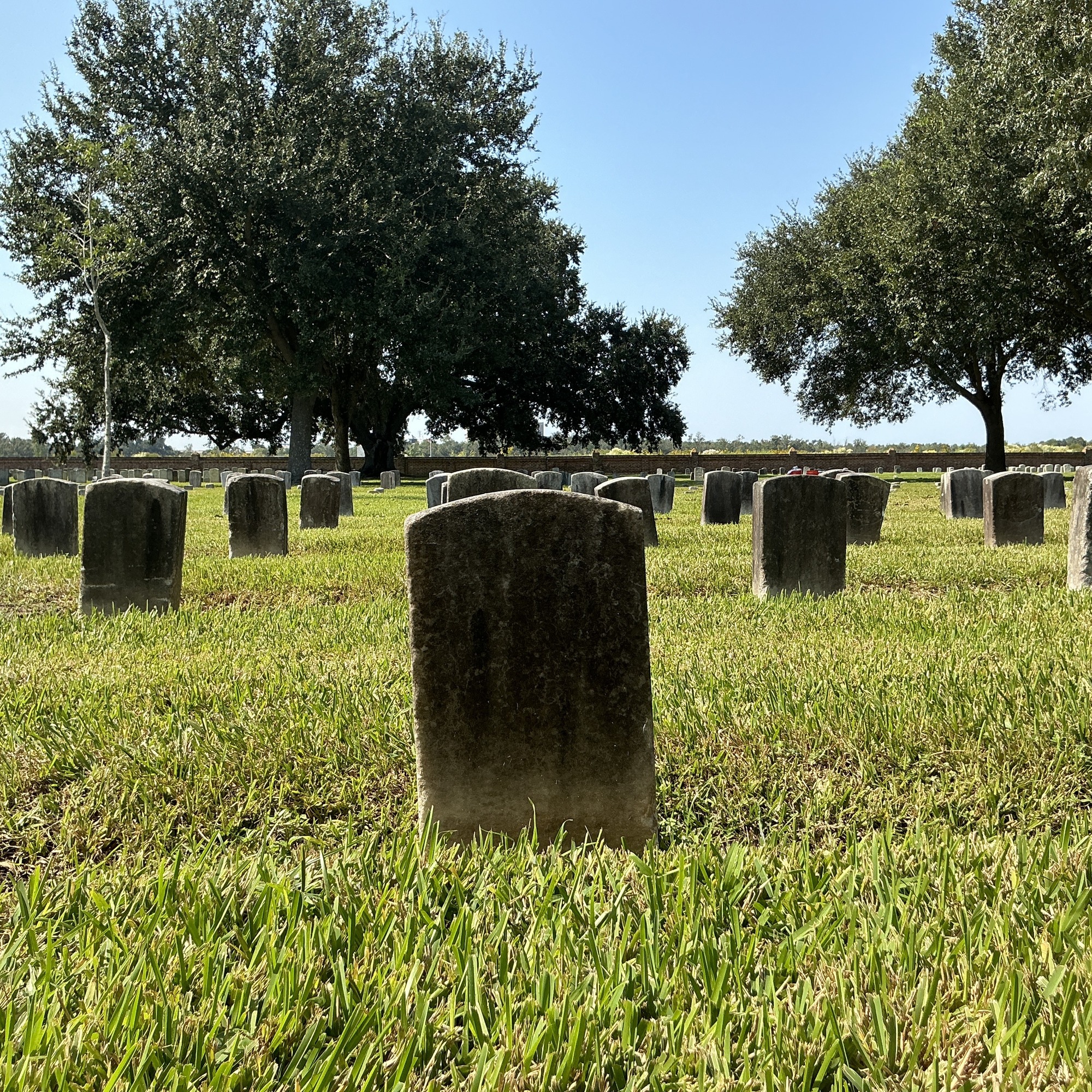Back of historic upright marble headstone with recessed shield face.
