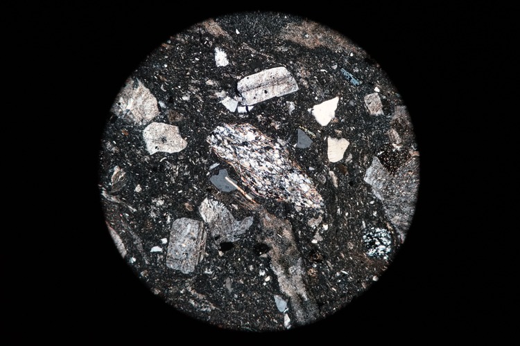 Circular microscopic image of rock structure.
