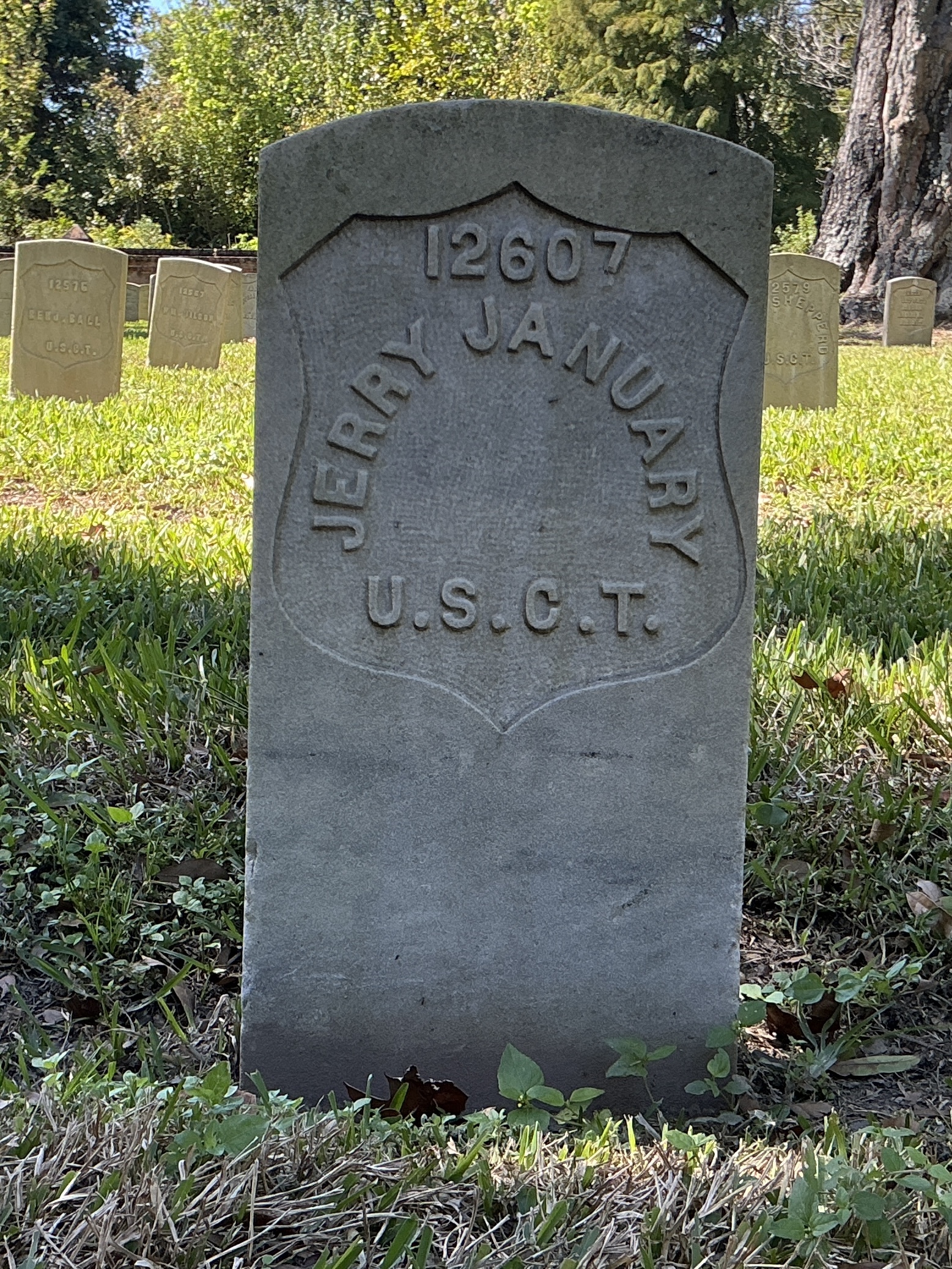 Front of historic upright marble headstone with recessed shield face.