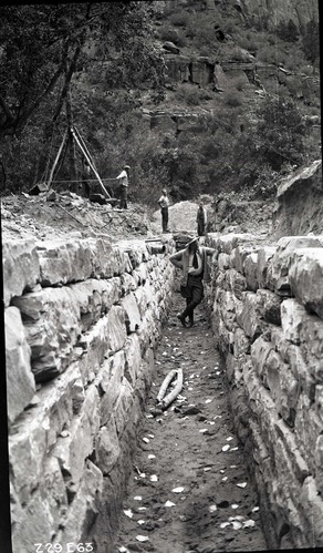 Rock-lined trench for the new sewage system extension.