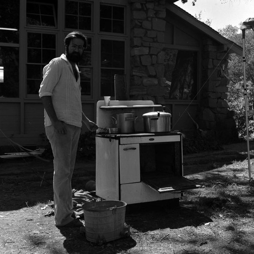 Hal Cannon cooking meals for participants on an old woodfired cook stove at the second annual Folklife Festival, Zion National Park Nature Center, September 1978.