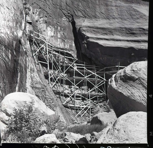 Crews upgrading water system at Temple of Sinawava - scaffolding up cliff face to spring.