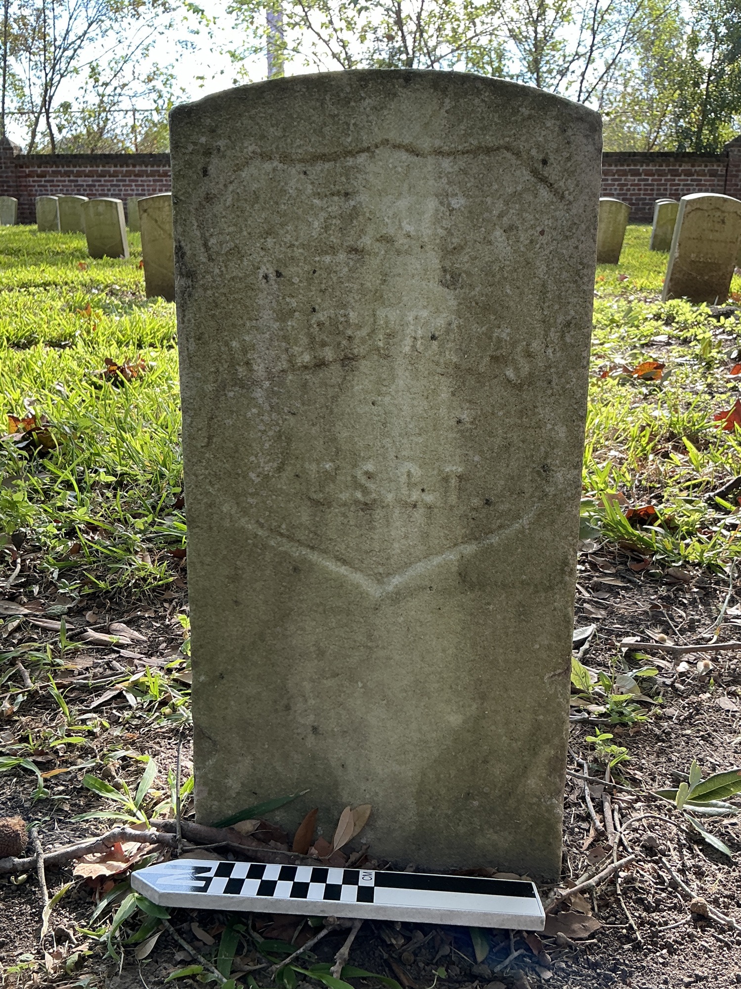 Extra image of historic upright marble headstone with recessed shield with recessed lettering face.