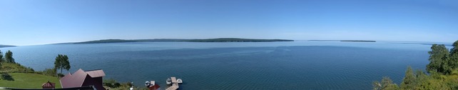 A big expanse of blue water dotted with wooded land in the distance. 