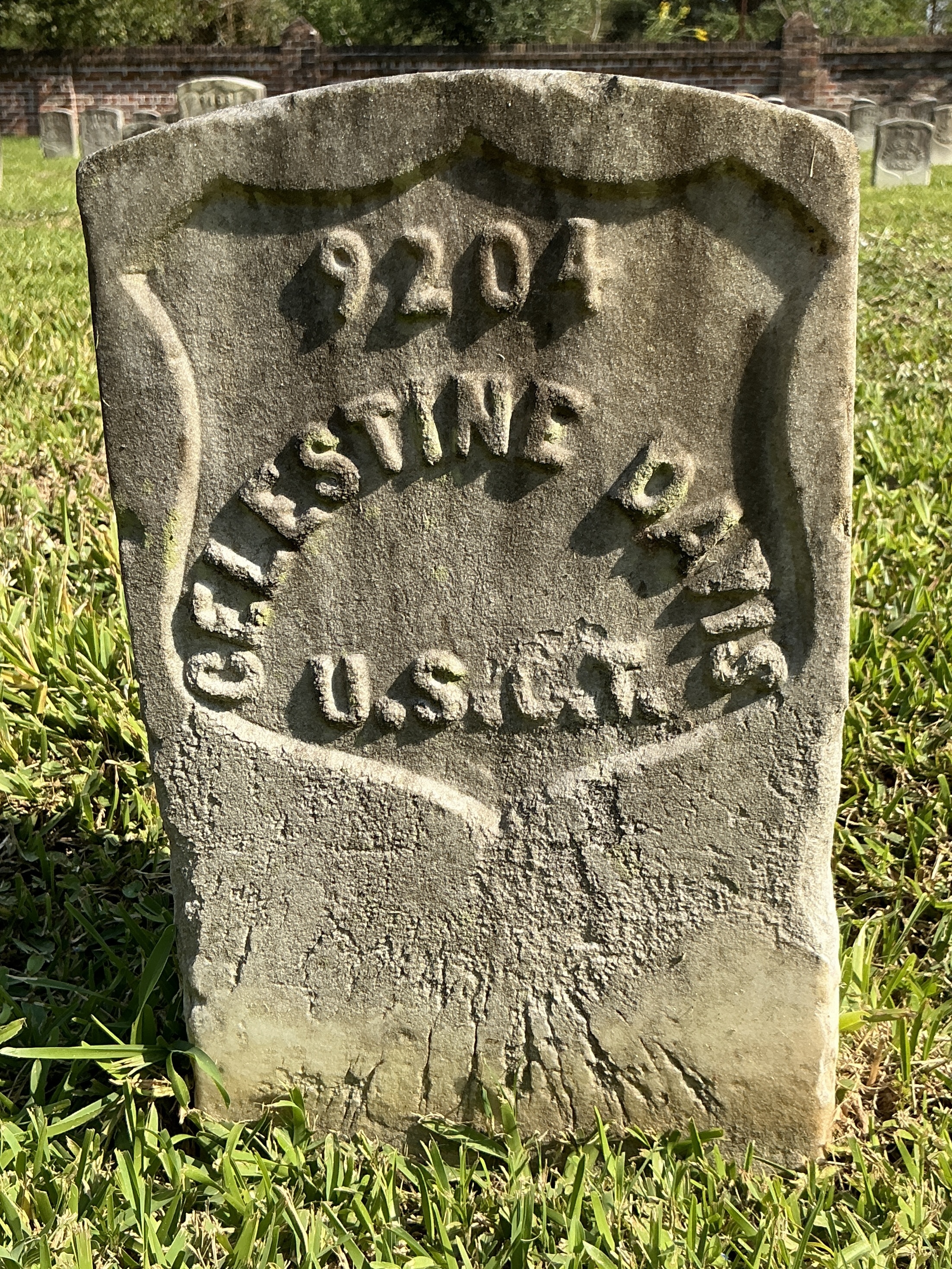 Front of historic upright marble headstone with recessed shield face.