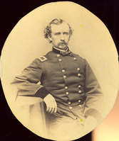 Brigadier General George Armstrong Custer in Military Uniform; Long Bust View. LIBI_00019_00318; This item is a card-mounted albumen photograph of Brigadier General George A. Custer in long bust view.  This oval-shaped photograph is 5 7/8