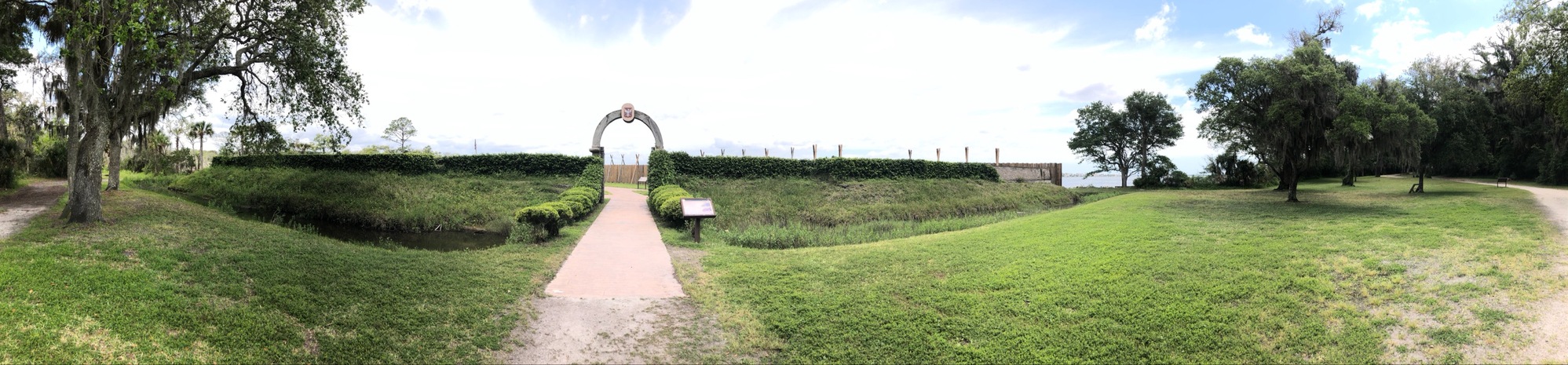 panoramic image of the arched fort gate with trees around the fort