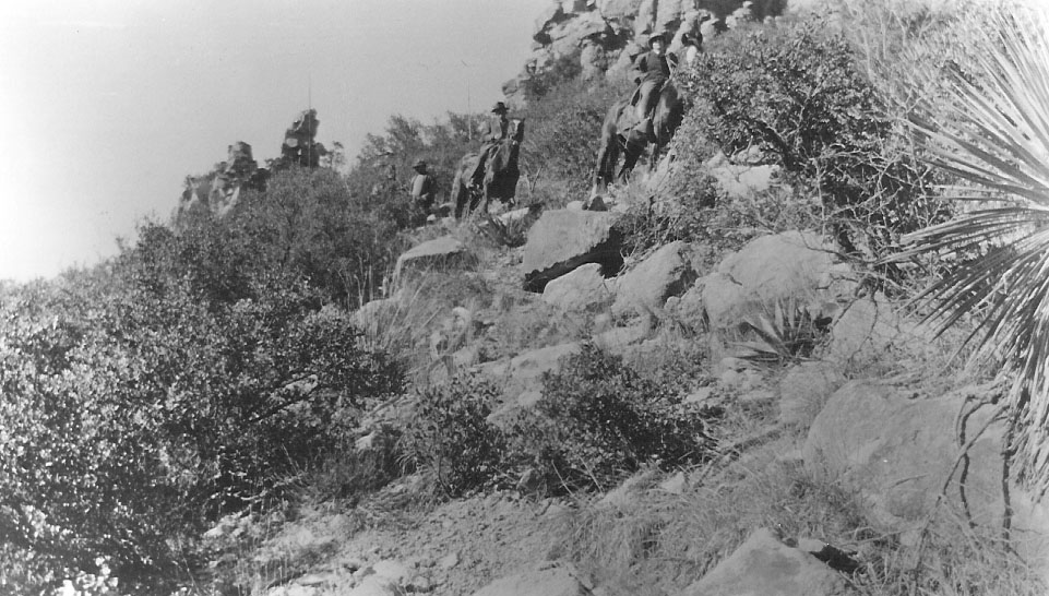 Horses and riders on a rocky trail. 