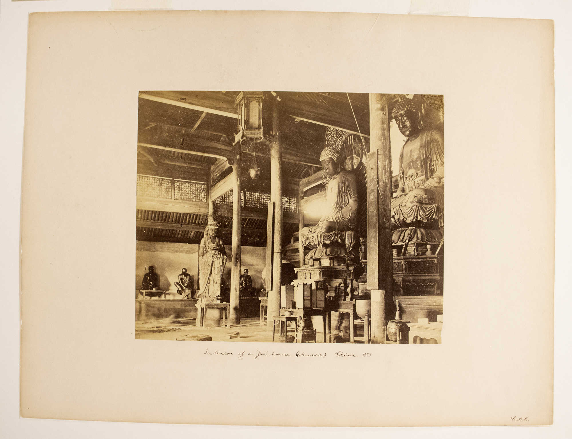 Sepia photograph with an inscription representing an interior with columns, Buddha statues, lanterns and drums