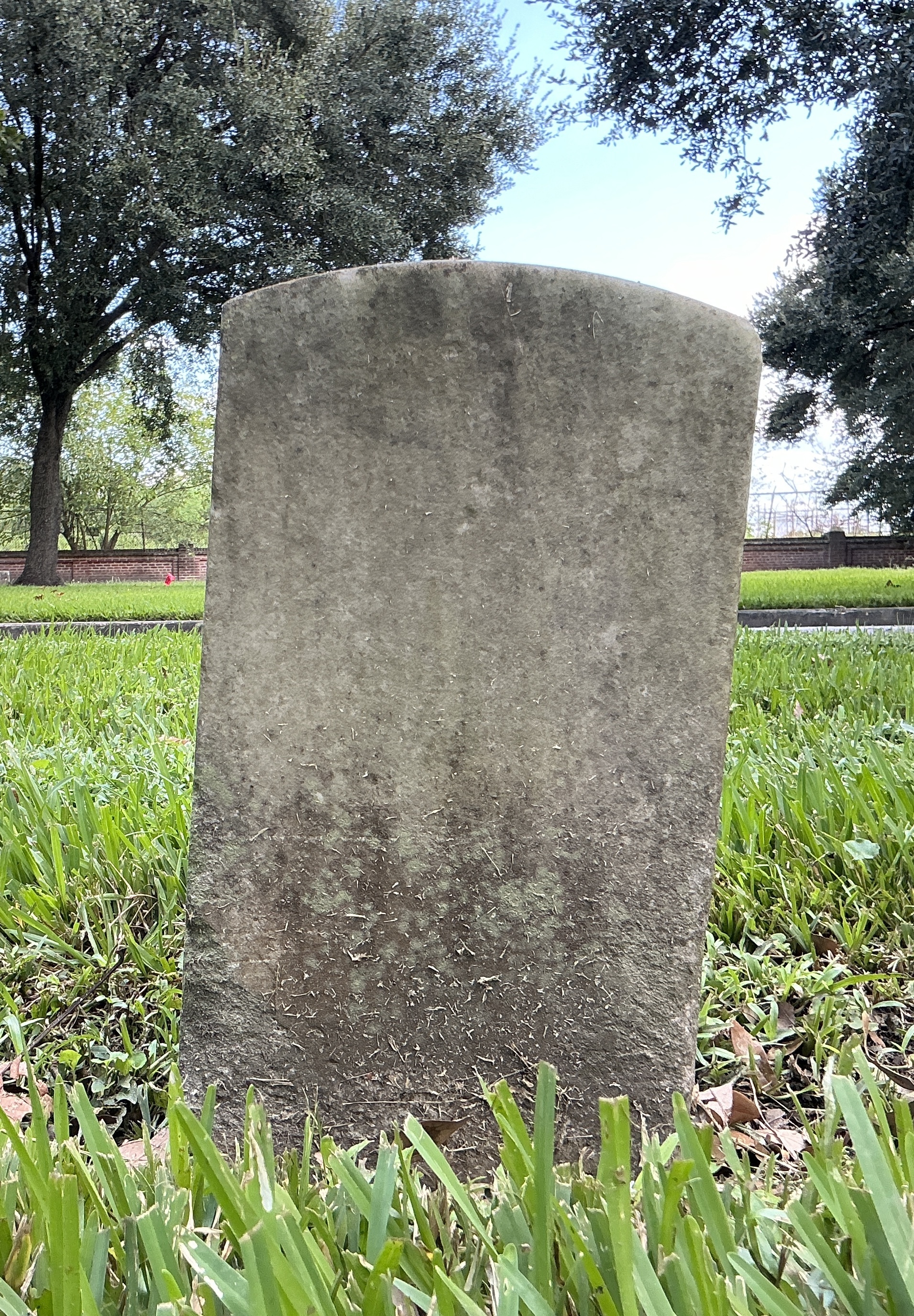 Back of historic upright marble headstone with recessed shield face.