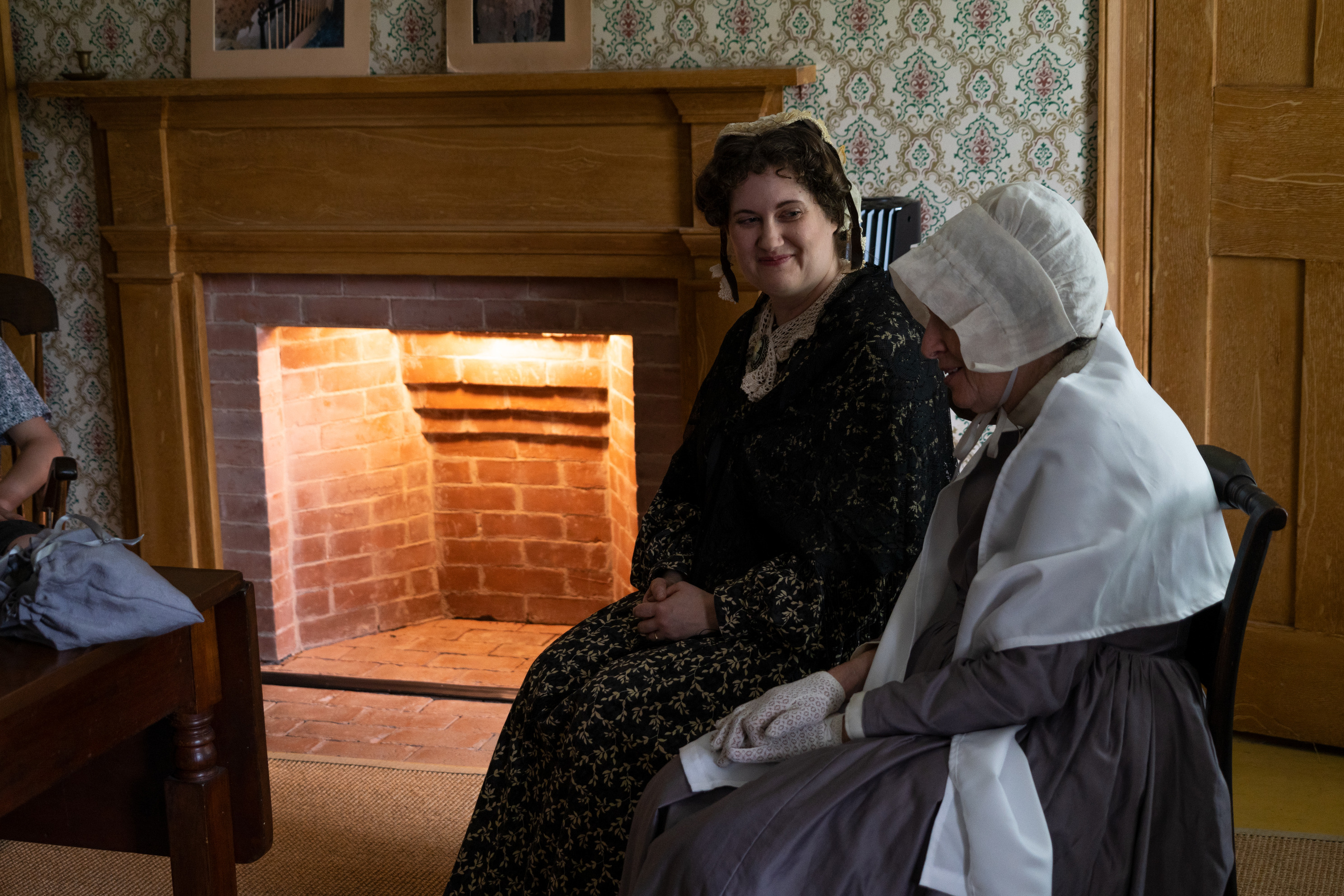 Visitors listen to a living history program in a historical home.