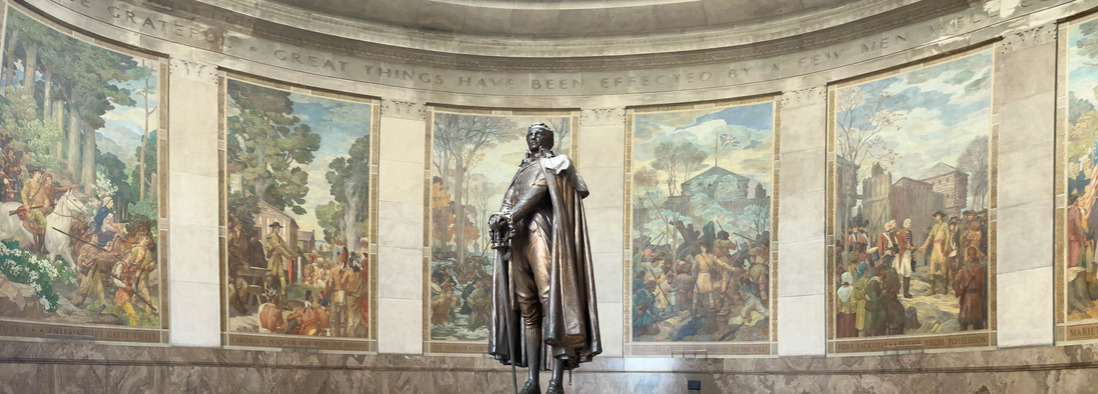 Statue of George Rogers Clark in a memorial's rotunda decorated with paintings of historical events 