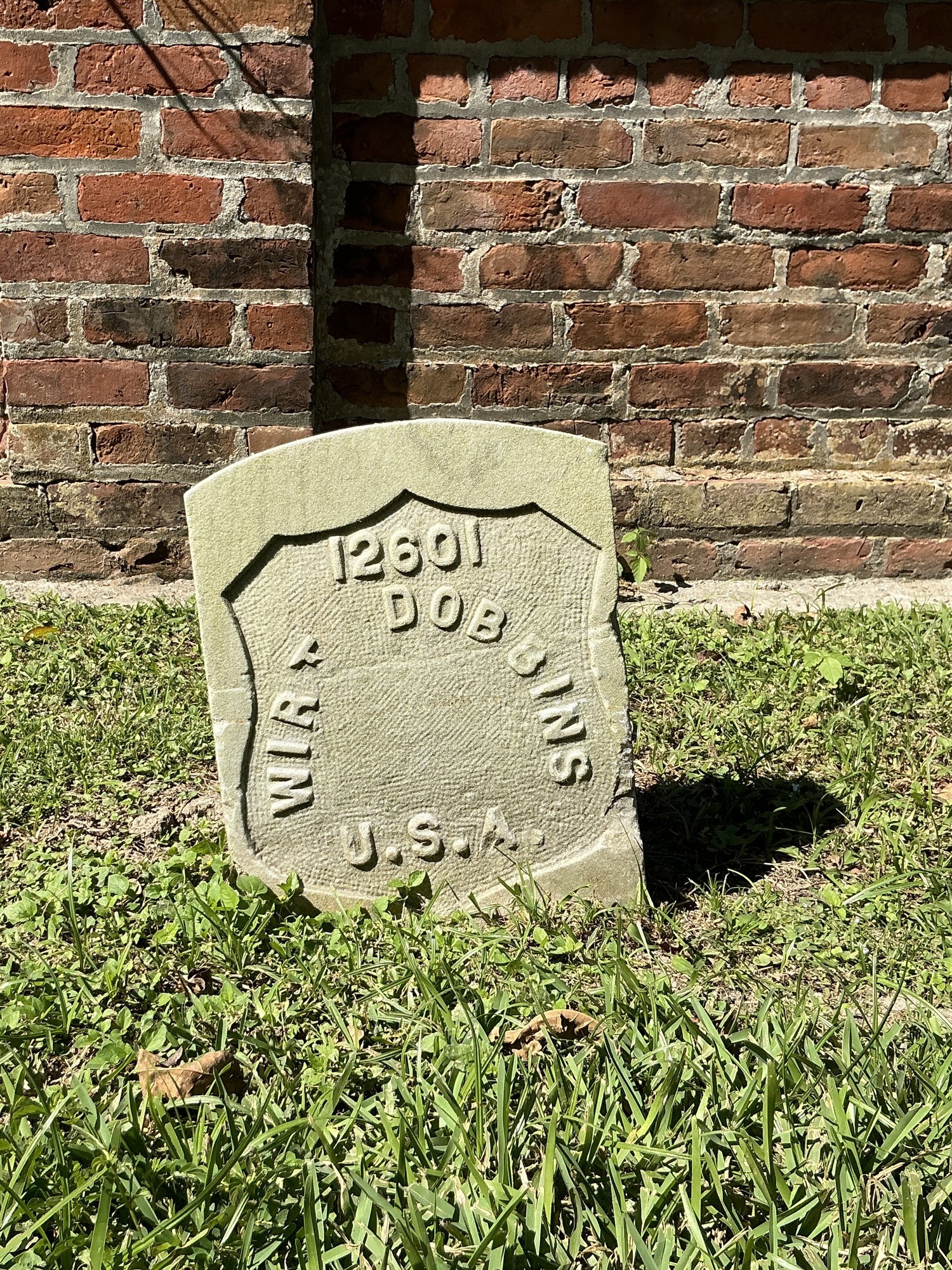 Front of historic upright marble headstone with recessed shield face.