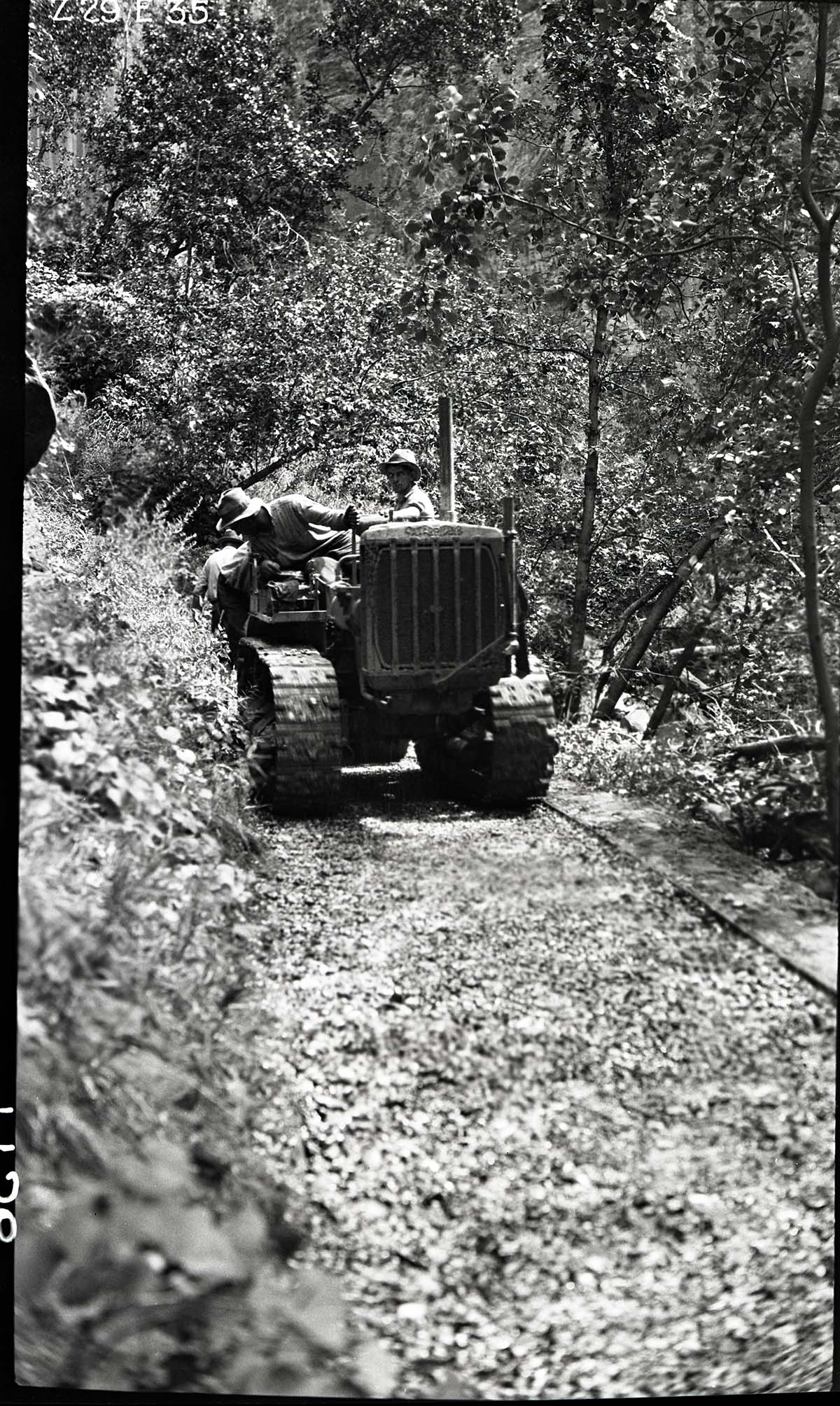 Narrows Trail construction- workmen on a caterpillar tractor pulling 1-1/2 ton roller over the base course.