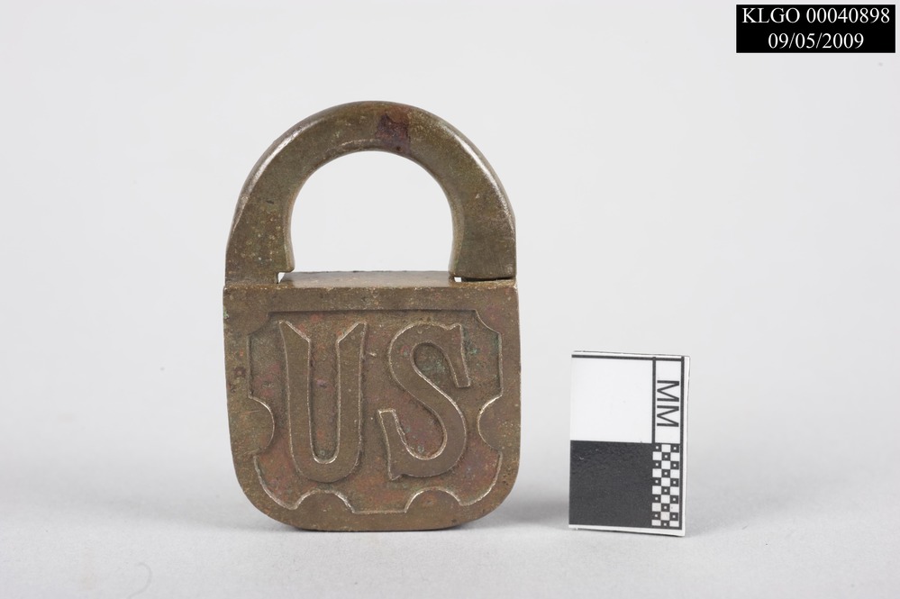 color photo of half of medium-sized, rectangular brass padlock reading, "US" on the front