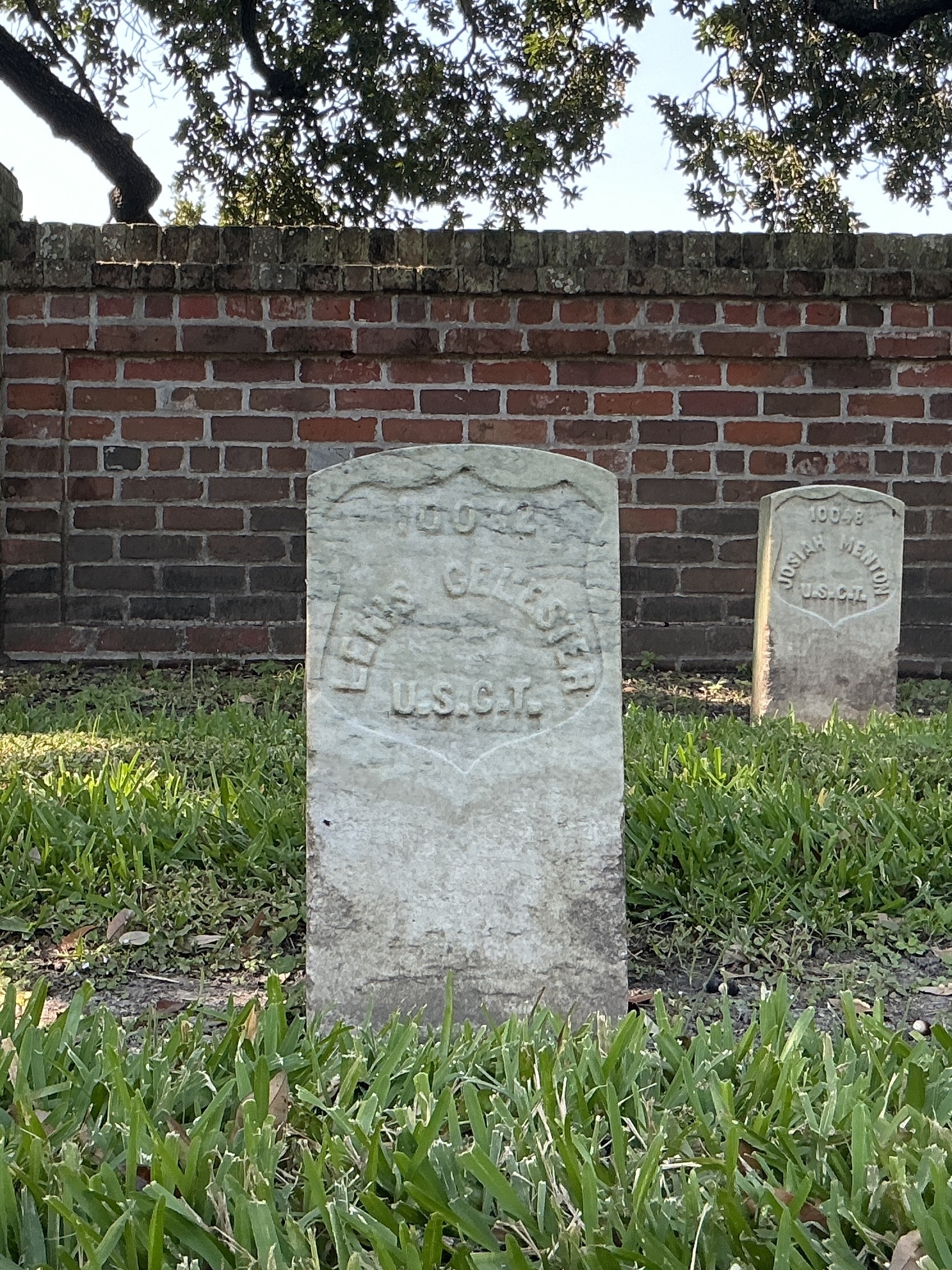 Front of historic upright marble headstone with recessed shield face.