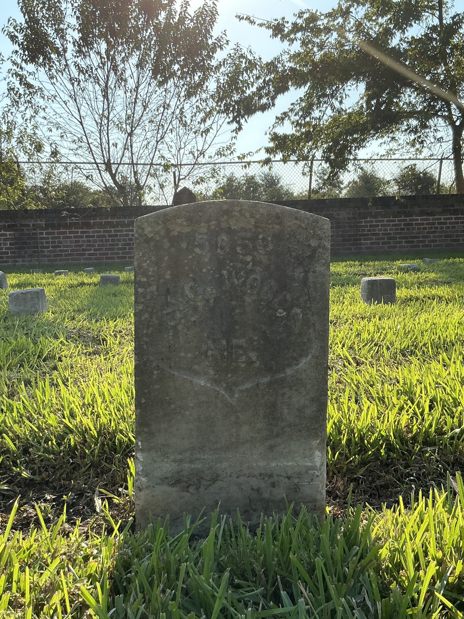 Front of historic upright marble headstone with recessed shield face.