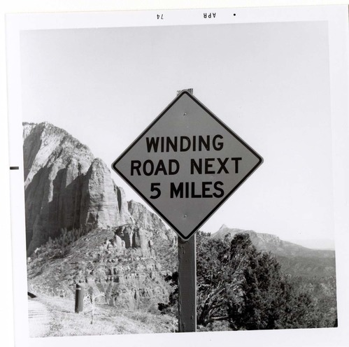 Road sign reading 'Winding Road Next 5 Miles' in Kolob Canyon.
